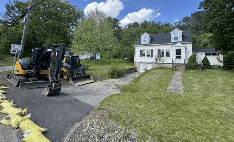 John Deere excavator and skid steer equipment on site preparing a residential driveway for asphalt paving in Barre Massachusetts.