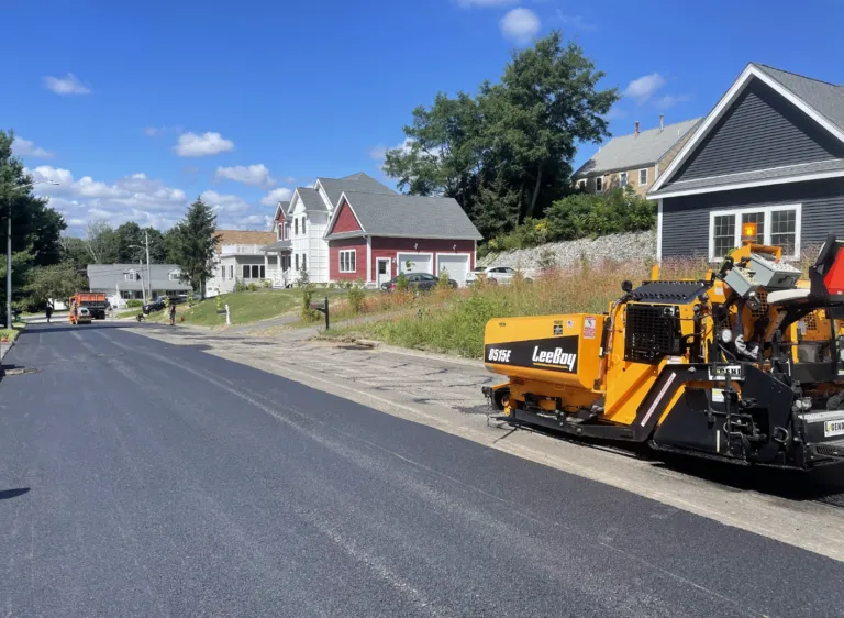 LeeBoy asphalt paver machine on site laying new roadway pavement in a residential Rutland Massachusetts neighborhood.